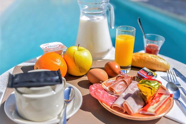 Breakfast by the outdoor pool at the Hôtel Résidence in Nissan-Lez-Ensérune
