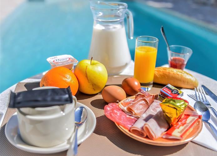 Breakfast by the outdoor pool at the Hôtel Résidence in Nissan-Lez-Ensérune